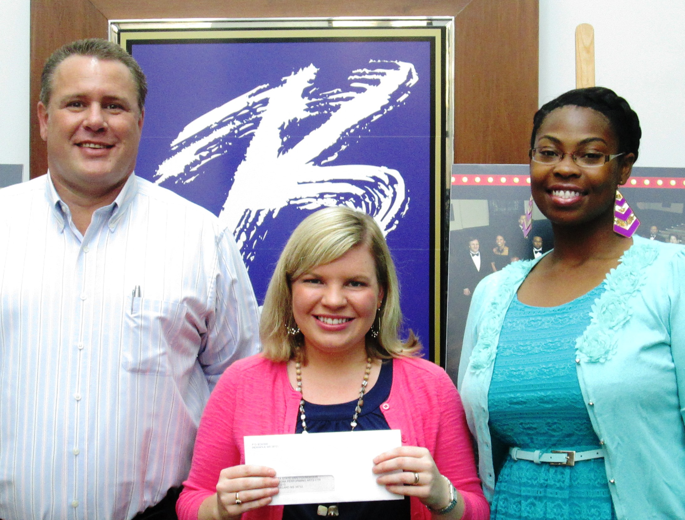 Damon Cranford (left), Director of Marketing, and Curlina Williams (right), Marketing Manager for Double Quick, Inc. present a check for Arts Education Fueled by Double Quick to Whitney Cummins (middle), BPAC Arts Education Coordinator